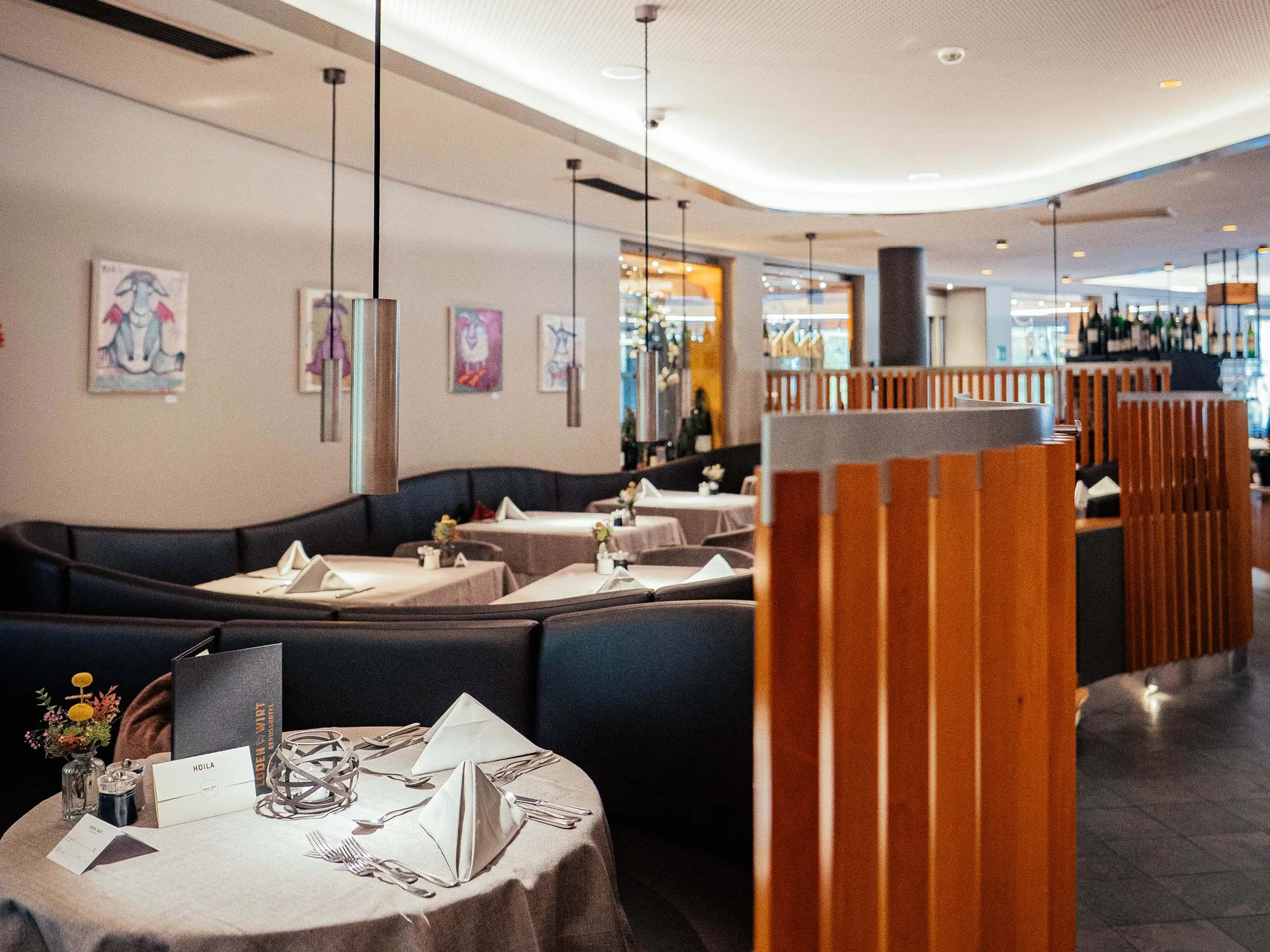 Der Lodenwirt in Vintl | Hotel, Residence & Restaurant Elegantes Restaurant mit gedeckten Tischen und moderner Beleuchtung