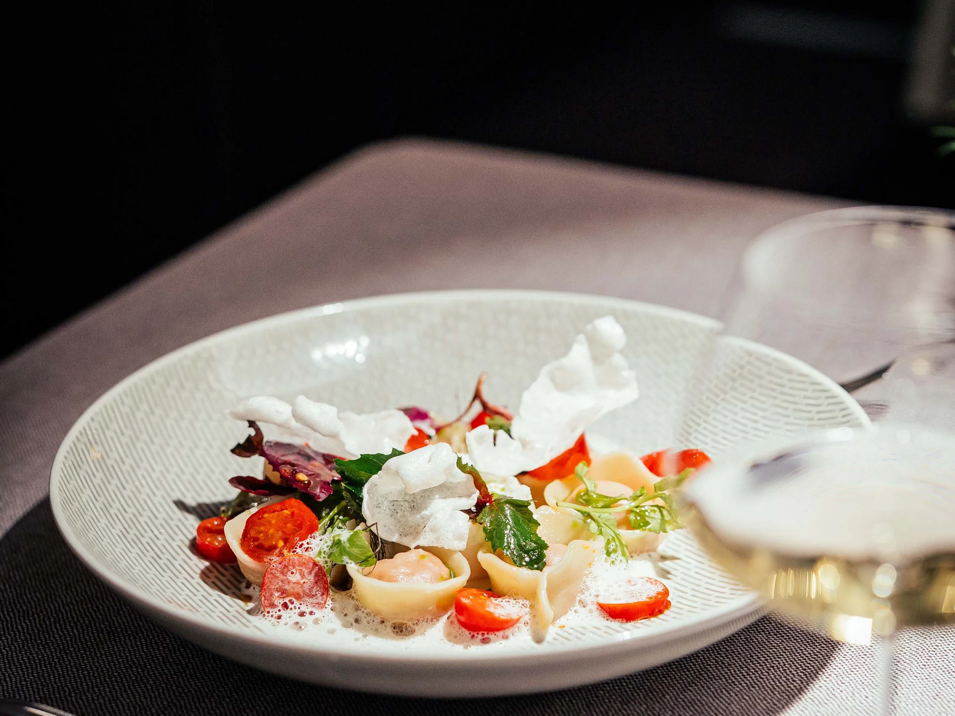 Der Lodenwirt in Vintl | Hotel, Residence & Restaurant Fein angerichtete Pasta mit Tomaten, Blättern und Schaum auf weißem Teller